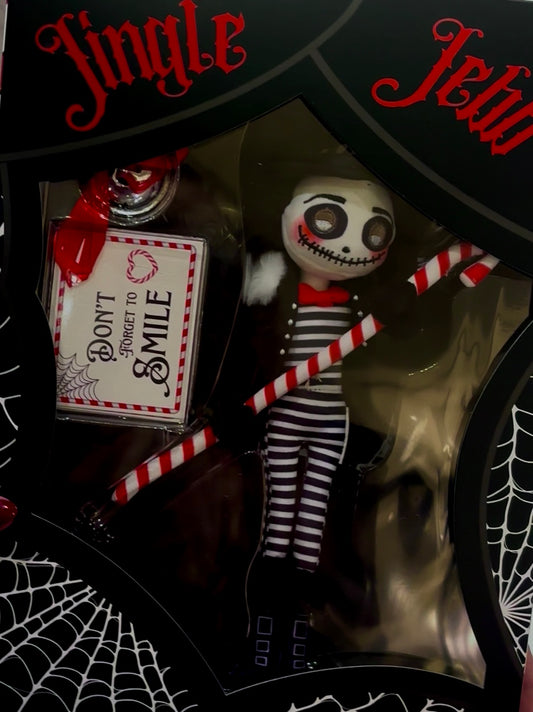 Halloween-themed figurine with striped pants and a sign in a decorative box.