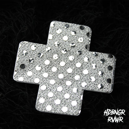 Single silver sequin cross-shaped pastie with mirror dot embellishment on dark textured background — Silver Xs by HDBNGR RVWR.