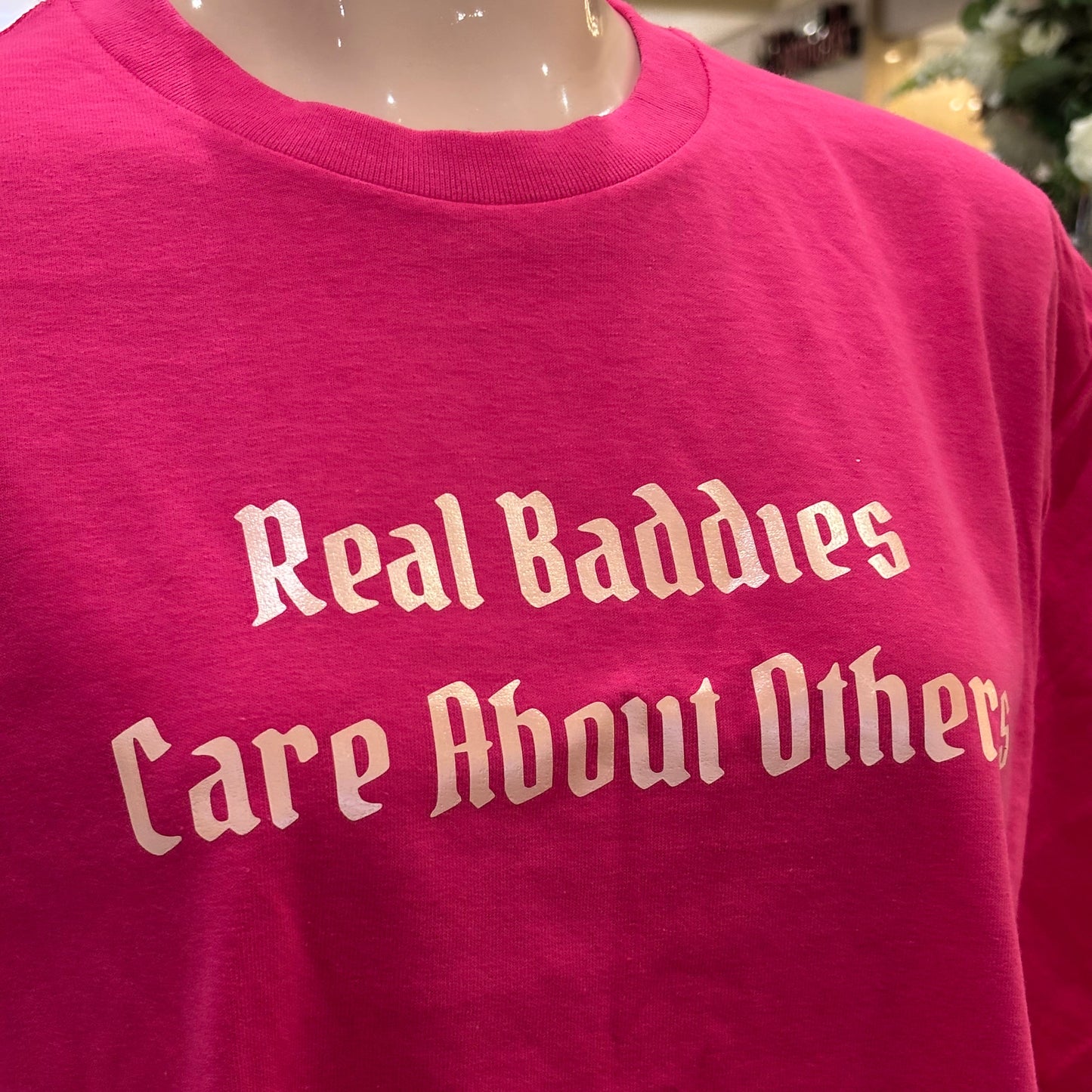 Pink t-shirt with white text on a blurred background