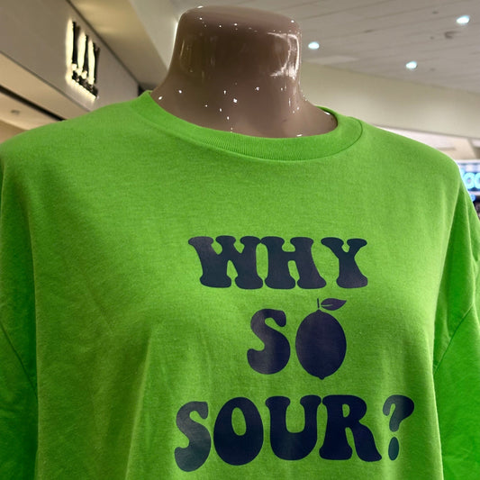 Green t-shirt with 'WHY SO SOUR?' text on a mannequin in a store setting.