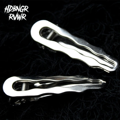 Two hair clips in silver and gunmetal wavy-edge finish on dark background — Abyss Waves V2 2PC Set by HDBNGR RVWR.