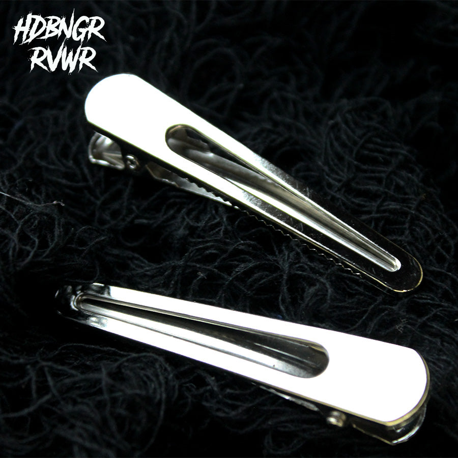 Two rounded open-oval silver hair clips on dark textured background — Y2K The Original by HDBNGR RVWR.