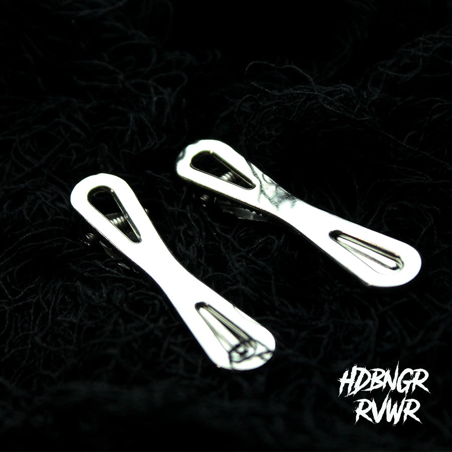 Two silver bow tie-shaped hair clips in V2 style on dark background with HDBNGR RVWR watermark.