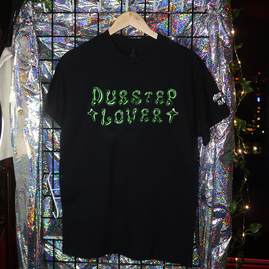 Black t-shirt with 'Dubstep Lovely' text on a hanger against a colorful, reflective background.
