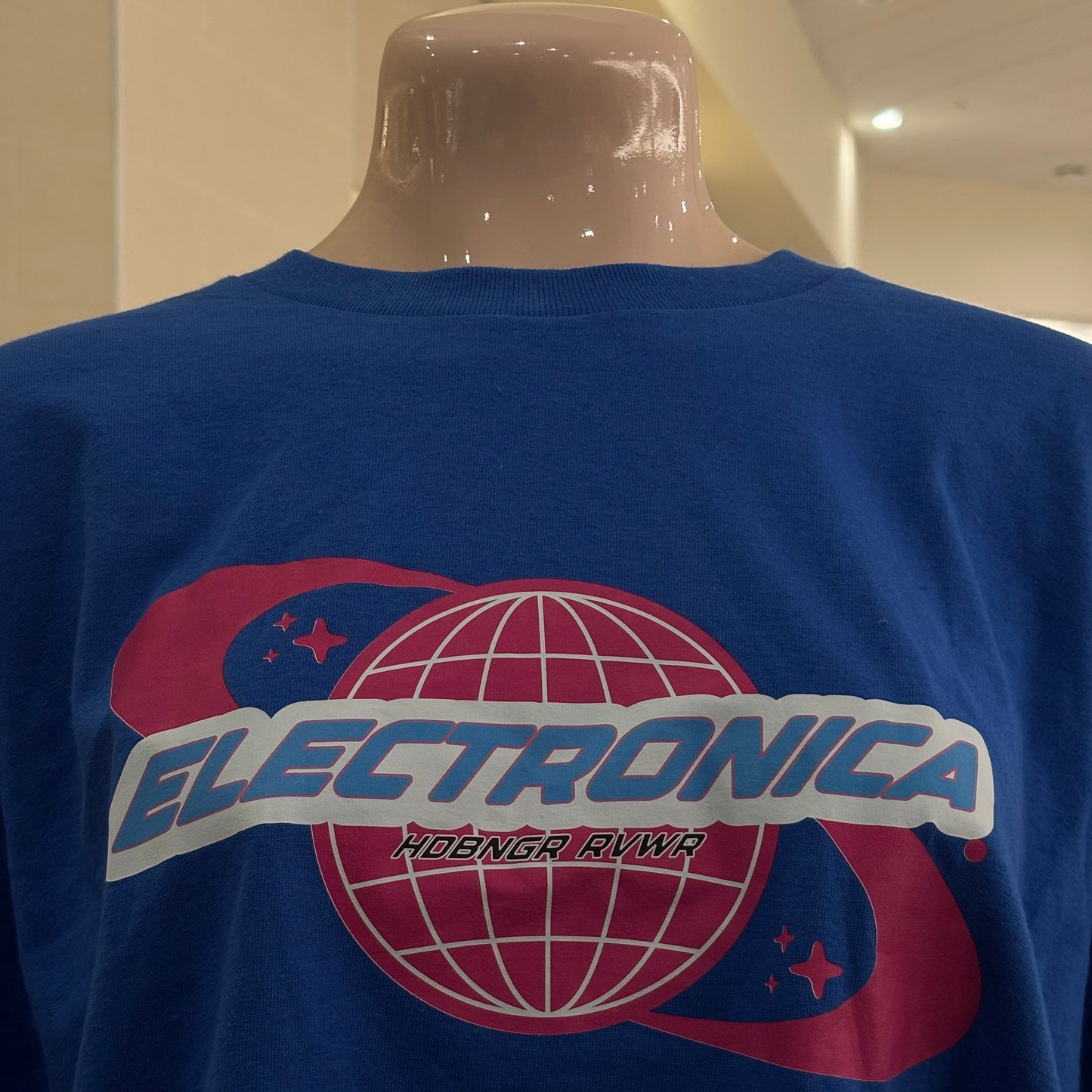 Blue shirt with a pink and white logo on a plain background