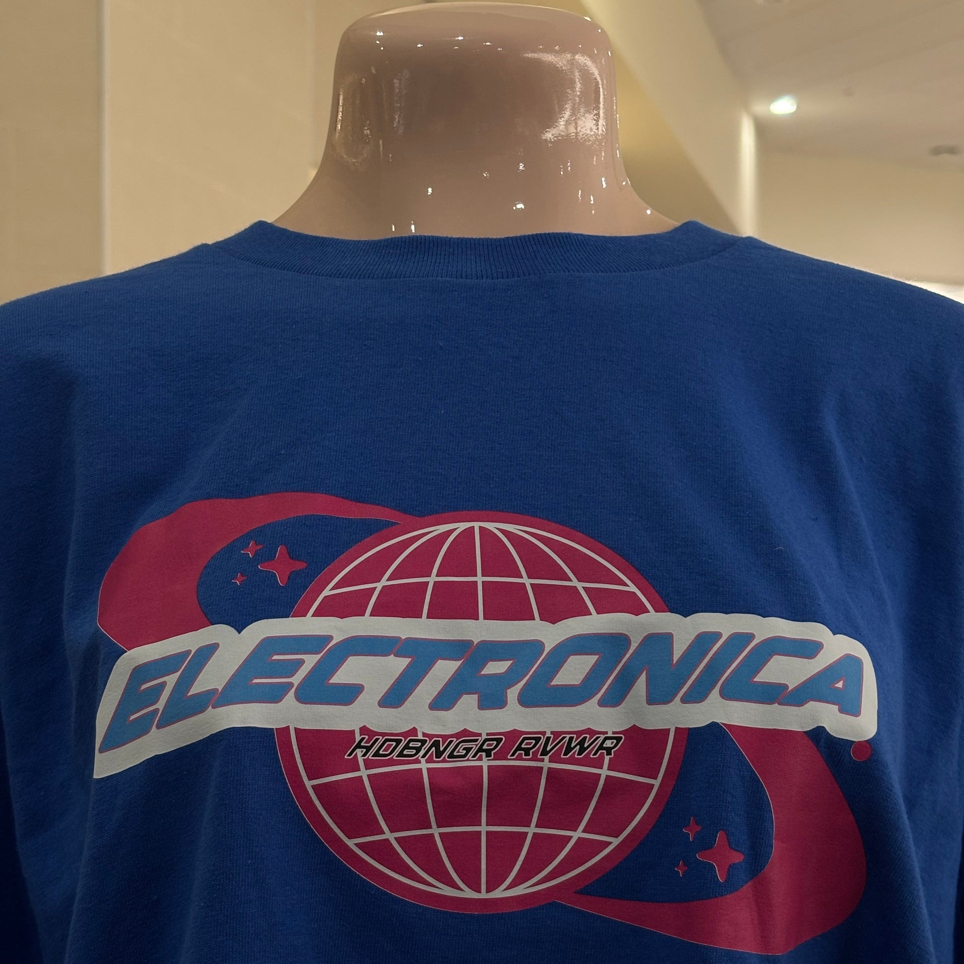 Blue shirt with a pink and white logo on a plain background