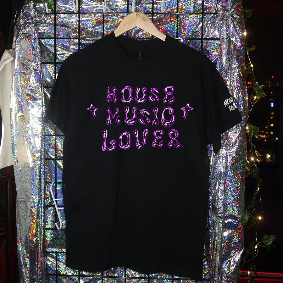 Black t-shirt with 'HARD TECHNO LOVER' text on a hanger against a reflective, multicolored background.