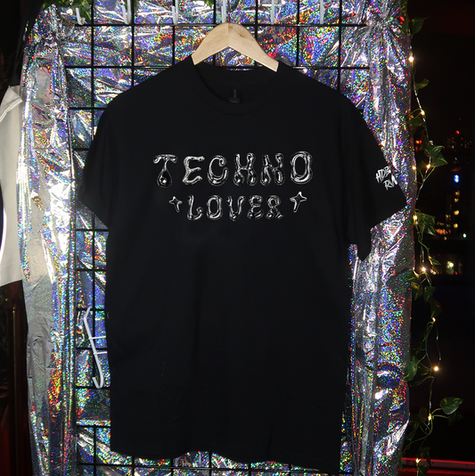 Black t-shirt with 'TECHNO LOVER' text on a hanger against a reflective, multicolored background.