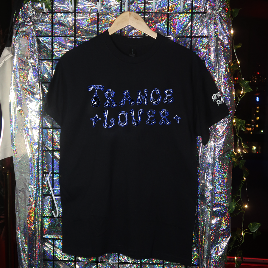 Black t-shirt with 'TECHNO LOVER' text on a hanger against a reflective, multicolored background.