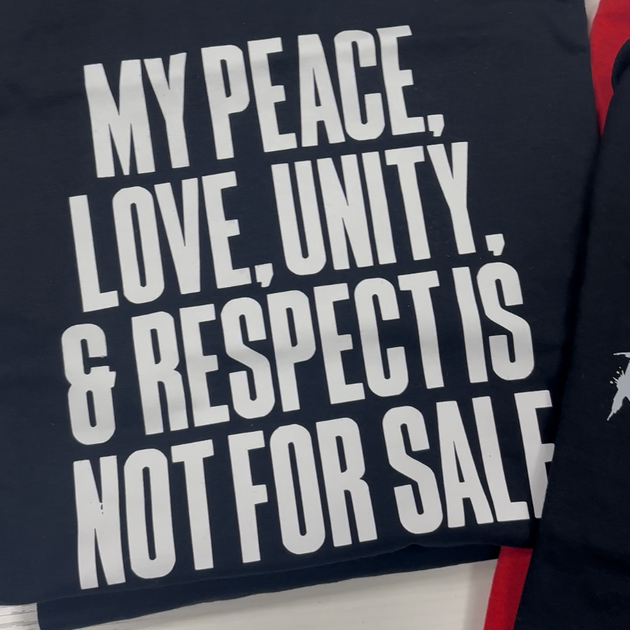 A black t-shirt with bold white text reading 'MY PEACE, LOVE, UNITY, & RESPECT IS NOT FOR SALE' laid flat on a white surface.